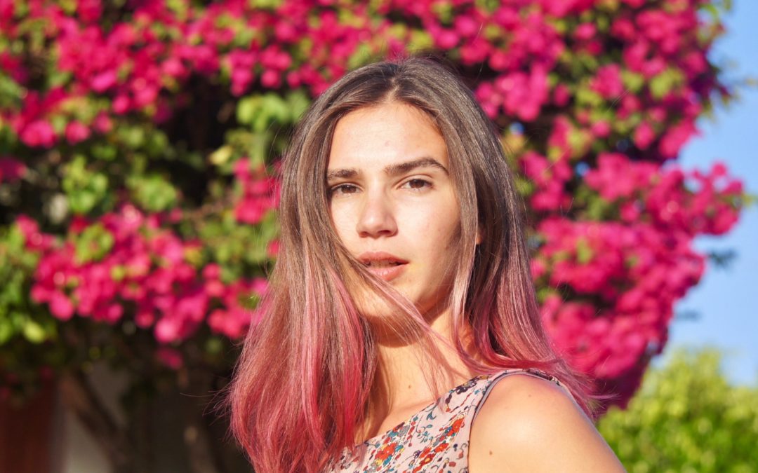 Ombré Hair -Girl with reddish pink ombré hair against flower bush