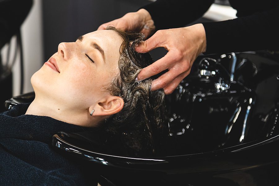 woman receiving a scalp massaging shampoo in a salon sink; Healthier hair concept