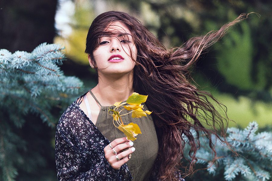 young woman with ombre hair in a park holding leaves