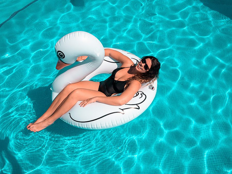 woman in swan float in a chlorine pool