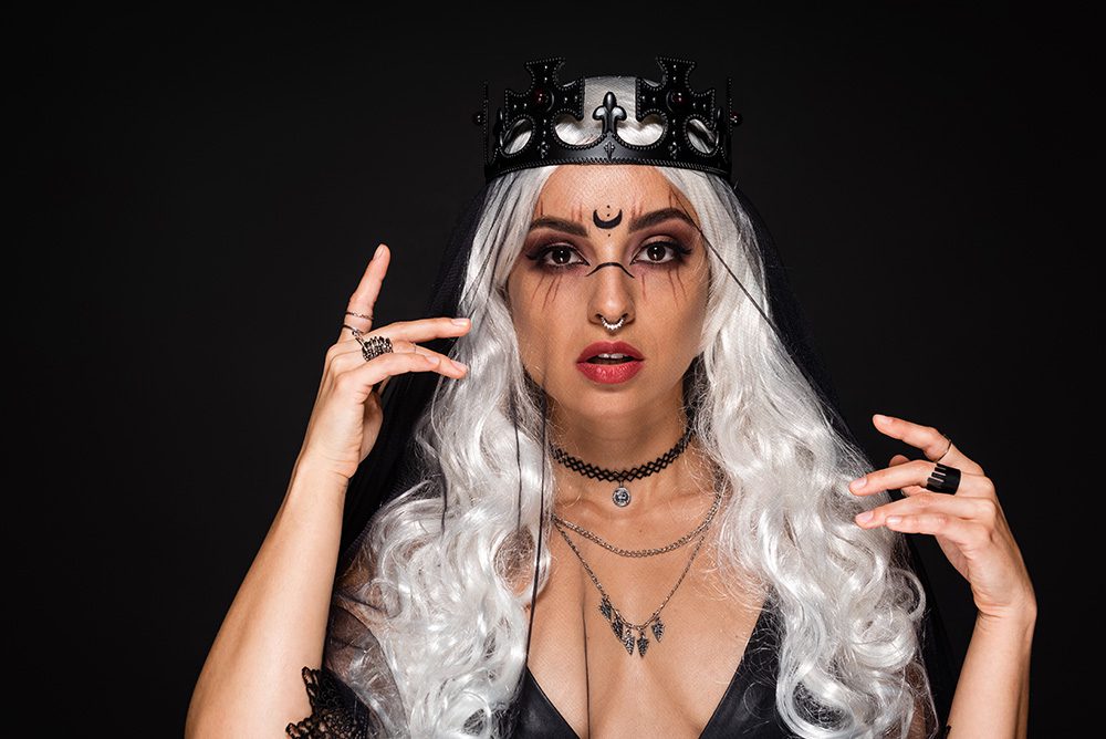 young woman in platinum wig and plastic crown, witchy makeup - halloween wig concept